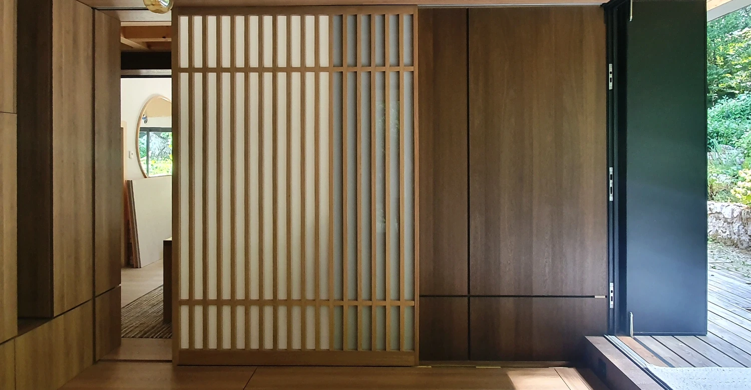 Agencement intérieur en bois avec claustra Agencement intérieur sur mesure en bois avec claustra et panneaux coulissants