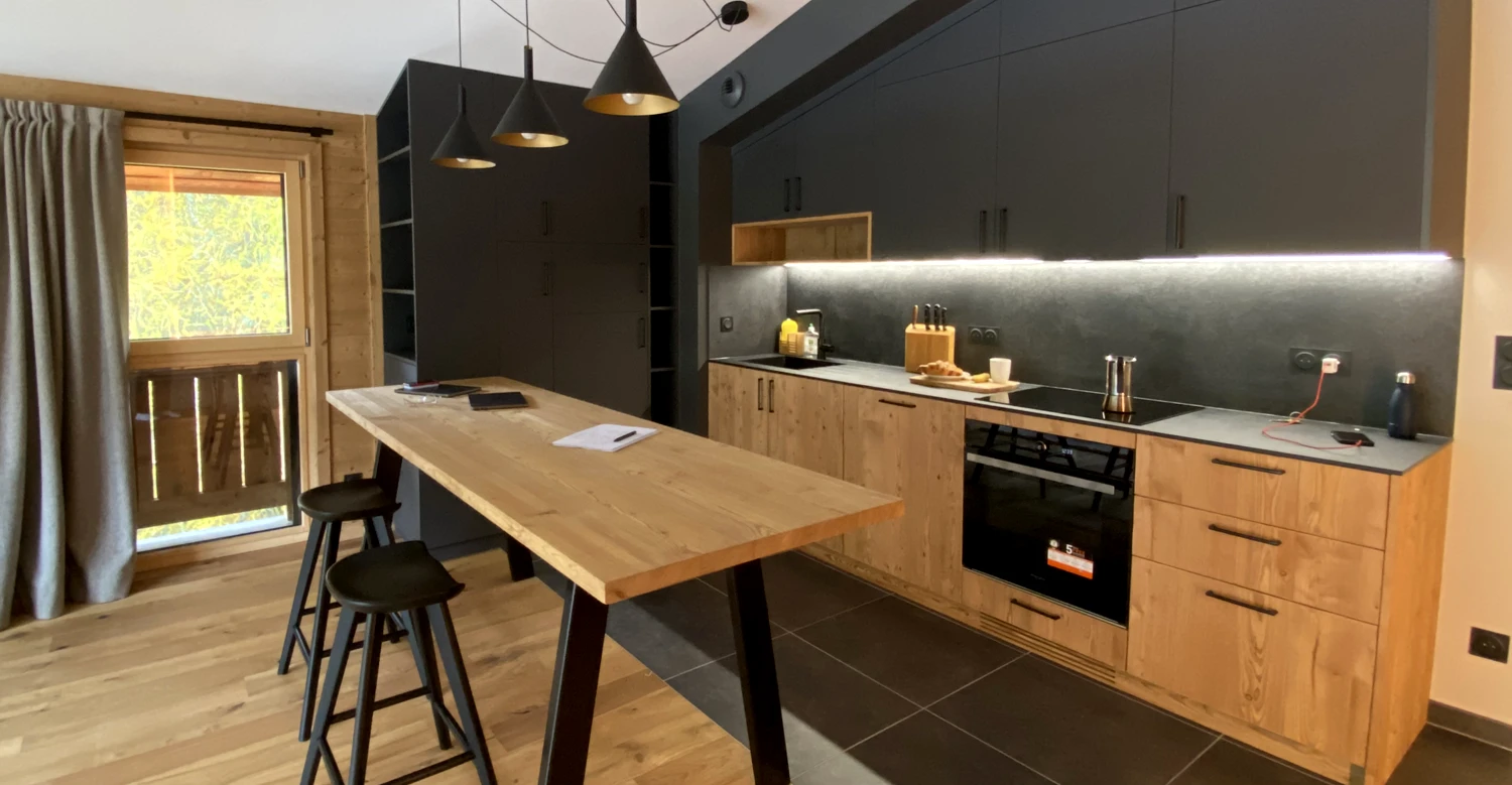 Cuisine sur mesure en bois dans un appartement de montagne Cuisine sur mesure en bois avec îlot et rangements intégrés dans un appartement de montagne