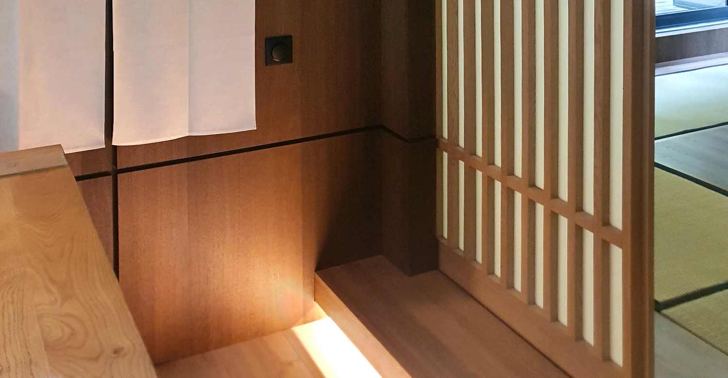 Détail agencement bois avec claustra Détail d’un agencement intérieur en bois avec claustra et éclairage indirect