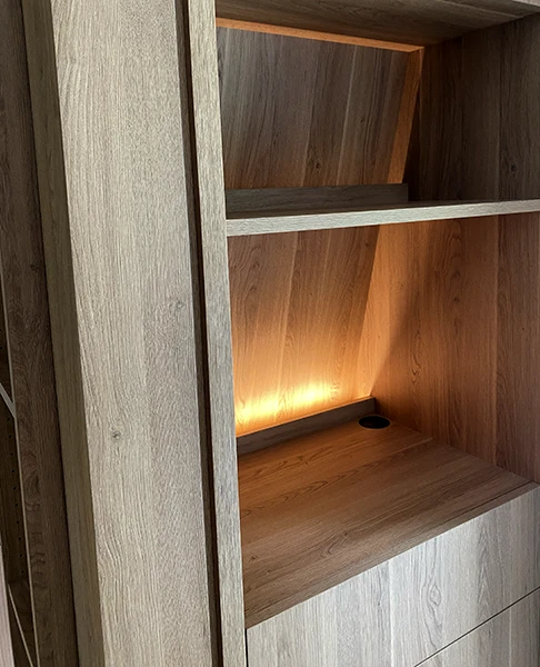 Détail mobilier bois sur mesure Détail d’un mobilier sur mesure en bois avec étagères et éclairage intégré