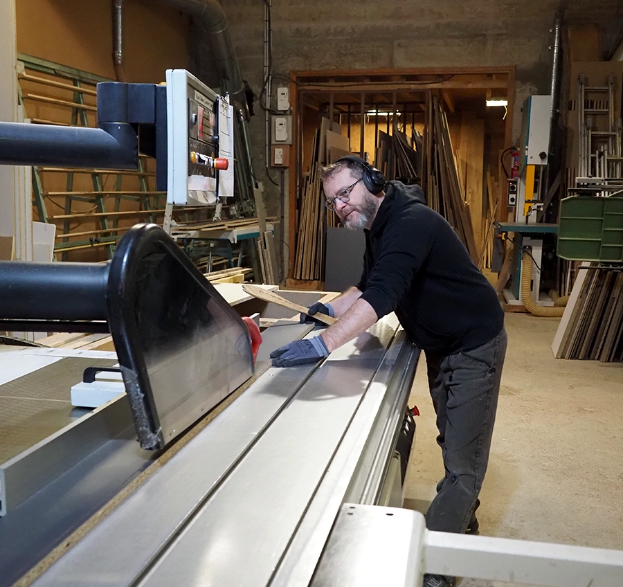 Fabrication de mobilier sur mesure en atelier Artisan travaillant à la fabrication de mobilier sur mesure dans un atelier de menuiserie