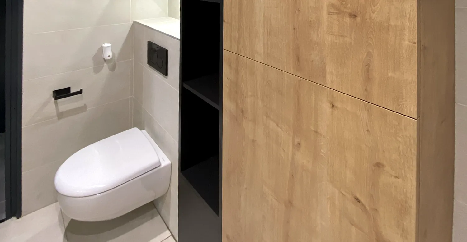 Meuble de rangement en bois dans WC avec agencement sur mesure Agencement de WC avec meuble de rangement en bois et niches intégrées dans un aménagement intérieur sur mesure
