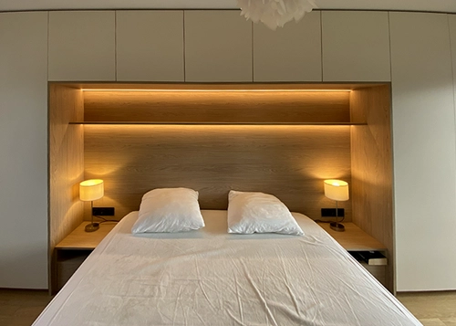 Pont de lit et rangements sur mesure Pont de lit avec rangements et éclairage intégré dans une chambre réalisée sur mesure